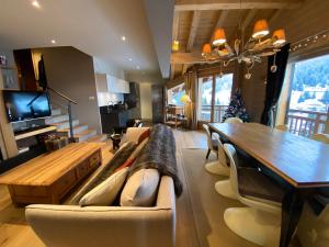 a living room with a table and a dining room at les craterelles in Courchevel