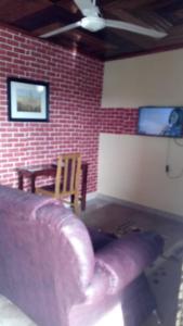 a living room with a couch and a brick wall at Rose Garden Apartments in Limbe