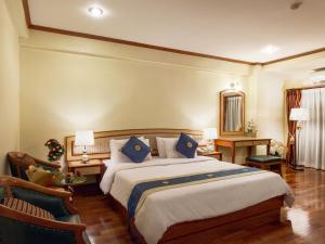 1 dormitorio con 1 cama grande con almohadas azules en Patumwan House, en Bangkok