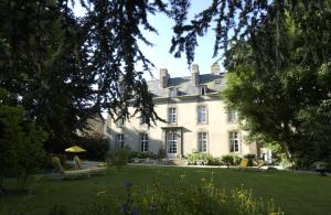 a large white house with a yard with chairs at Malouinière Le Valmarin in Saint Malo