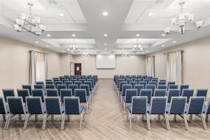 an empty room with blue chairs and a screen at Holiday Inn Express & Suites Greenville-I-85 & Woodruff Rd by IHG in Greenville +41 photos