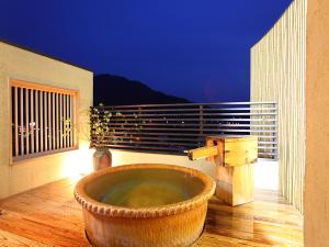 bañera grande en el suelo de un balcón en Ryokan Biyunoyado, en Yamanouchi