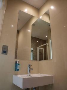 ein Bad mit einem Waschbecken und einem Spiegel in der Unterkunft Simply Rooms & Suites in London