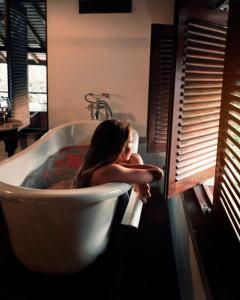 Eine Frau sitzt in einer Badewanne in der Unterkunft Tamarind Hill by Asia Leisure in Galle