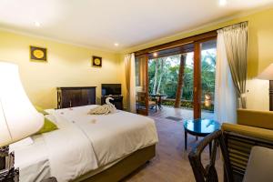 a hotel room with a bed and a balcony at Umasari Rice Terrace Villa in Tabanan