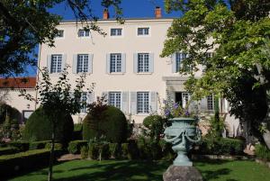 una gran casa blanca con una estatua delante de ella en Demeure Bouquet, en Ambierle