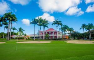 a golf course with palm trees and a building at DUPLEX 5 ÉTOILES ENTRE MARINA ET GOLF INTERNATIONAL in Saint-François