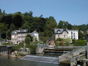 una ciudad con casas y un puente sobre un cuerpo de agua en le chalet de la vallée en Bouquelon