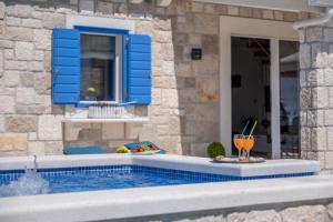 a swimming pool with a drink next to a house at Villa Blue Sky in Bol