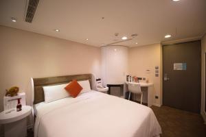 A bed or beds in a room at Ximen Airline Hotel