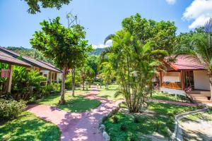 a resort yard with palm trees and buildings at Nice Beach Resort Koh Pha-ngan in Thong Nai Pan Yai
