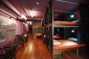 a room with bunk beds and a table and chairs at K Space Inn 569 in Singapore