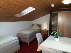 a room with two beds and a table and a window at Pension Sonnenhof in Mieming