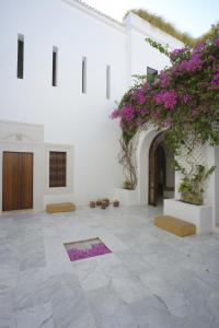 un patio con flores púrpuras en un edificio blanco en Dar Sabri, en Nabeul