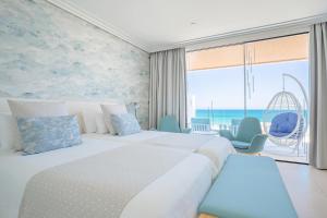 a hotel room with two beds and a large window at Hotel Lava Beach in Puerto del Carmen