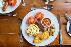 un plato de comida con huevos salchichas patatas y frijoles en Holly Lodge Guest House with FREE off site health club, en Windermere