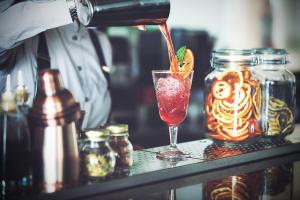 a person is pouring a drink into a glass at Hotel Lava Beach in Puerto del Carmen