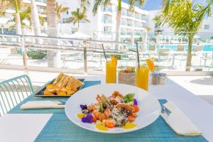 a table with a plate of food and a plate of food at Hotel Lava Beach in Puerto del Carmen