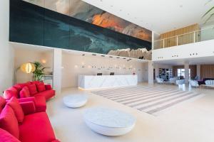a living room with red furniture and a large painting at Hotel Lava Beach in Puerto del Carmen