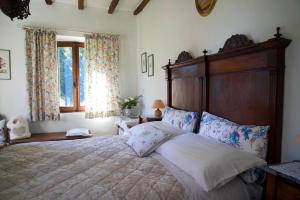 1 dormitorio con 1 cama grande y cabecero de madera en Agriturismo Il Caio, en Cetona