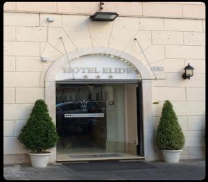 a store front of a hotel building with two bushes at Hotel Elide in Rome