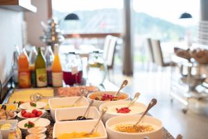 une table recouverte de bols de nourriture avec cuillères dans l'établissement Hotel am Hang, à Soprabolzano