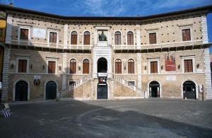 um grande edifício de tijolos com uma escada em frente em MarcheAmore - Bottega di Giacomino for art lovers, with private courtyard em Fermo