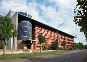 a building on a street with a road at TRYP by Wyndham Halle in Halle an der Saale