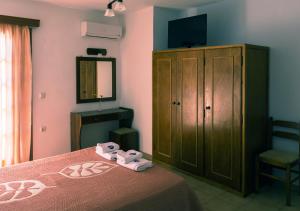 - une chambre avec un lit, une armoire et une télévision dans l'établissement Drymna, à Trizonía