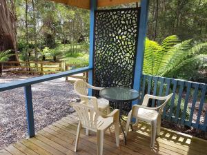 a patio with a table and chairs on a porch at Strahan Retreat Holiday Park in Strahan