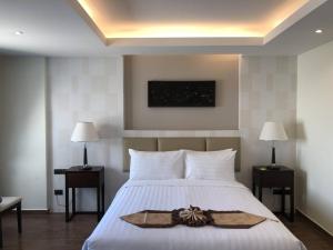 a bedroom with a white bed with a bow on it at Suvarnabhumi Ville Airport Hotel in Lat Krabang