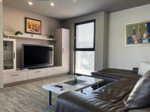 a living room with a couch and a flat screen tv at Apartment Trimontium 2 in Plovdiv