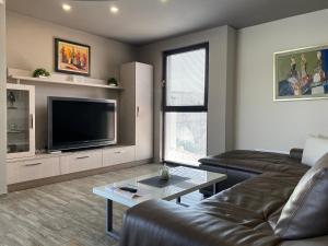 Una sala de estar con un sofá y un televisor de pantalla plana. en Apartment Trimontium 2, en Plovdiv