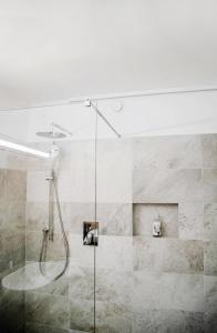 um chuveiro com uma porta de vidro na casa de banho em Hotel am Hang em Soprabolzano
