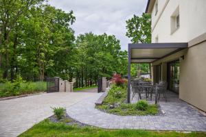 un patio avec une table et des chaises à côté d'un bâtiment dans l'établissement Penzion Lesni, à Milovice