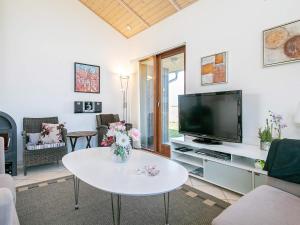 a living room with a table and a tv at 8 person holiday home in Ulfborg in Thorsminde