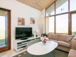 a living room with a tv and a couch and a table at 8 person holiday home in Ulfborg in Thorsminde