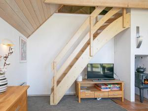 Mosevråにある10 person holiday home in Oksb lのリビングルーム(木製の階段、テレビ付)