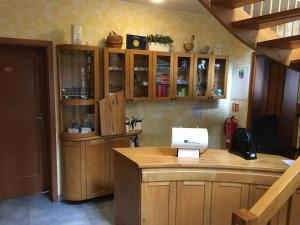 a bar with wooden cabinets and a laptop on a counter at Hotel Sirákov in Liptál