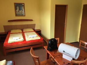 a bedroom with a bed and a table with a fan at Hotel Sirákov in Liptál