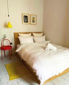 a bedroom with a white bed with a cat laying on it at Old Town Studio in Xanthi