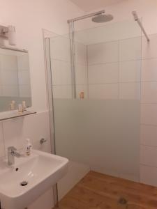 uma casa de banho branca com um lavatório e um chuveiro em Ferienwohnung Angelika em Wilhelmshaven