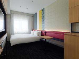 a hotel room with a bed and a table at Mitsui Garden Hotel Kyoto Shijo in Kyoto
