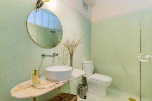 een badkamer met een wastafel, een spiegel en een toilet bij UNIQUE Modernist Duplex apartment & PARKING in Porto