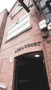 a brick building with an entrance to a akhtar court at Asha Court Serviced Apartments in Worcester