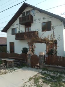 una casa bianca con una recinzione di legno di fronte di Corsarul a Crișan