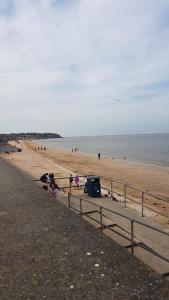 a group of people sitting on a beach at Milas Place in Leysdown-on-Sea