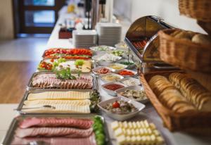 un buffet con carnes, quesos y otros alimentos en Biała Akacja Resort & Business, en Prudnik