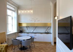a kitchen with a table and chairs in a room at Glamour apartment in Liepāja
