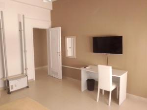 a room with a white desk and a tv on the wall at MAGNA GRECIA B&B in Reggio Calabria
